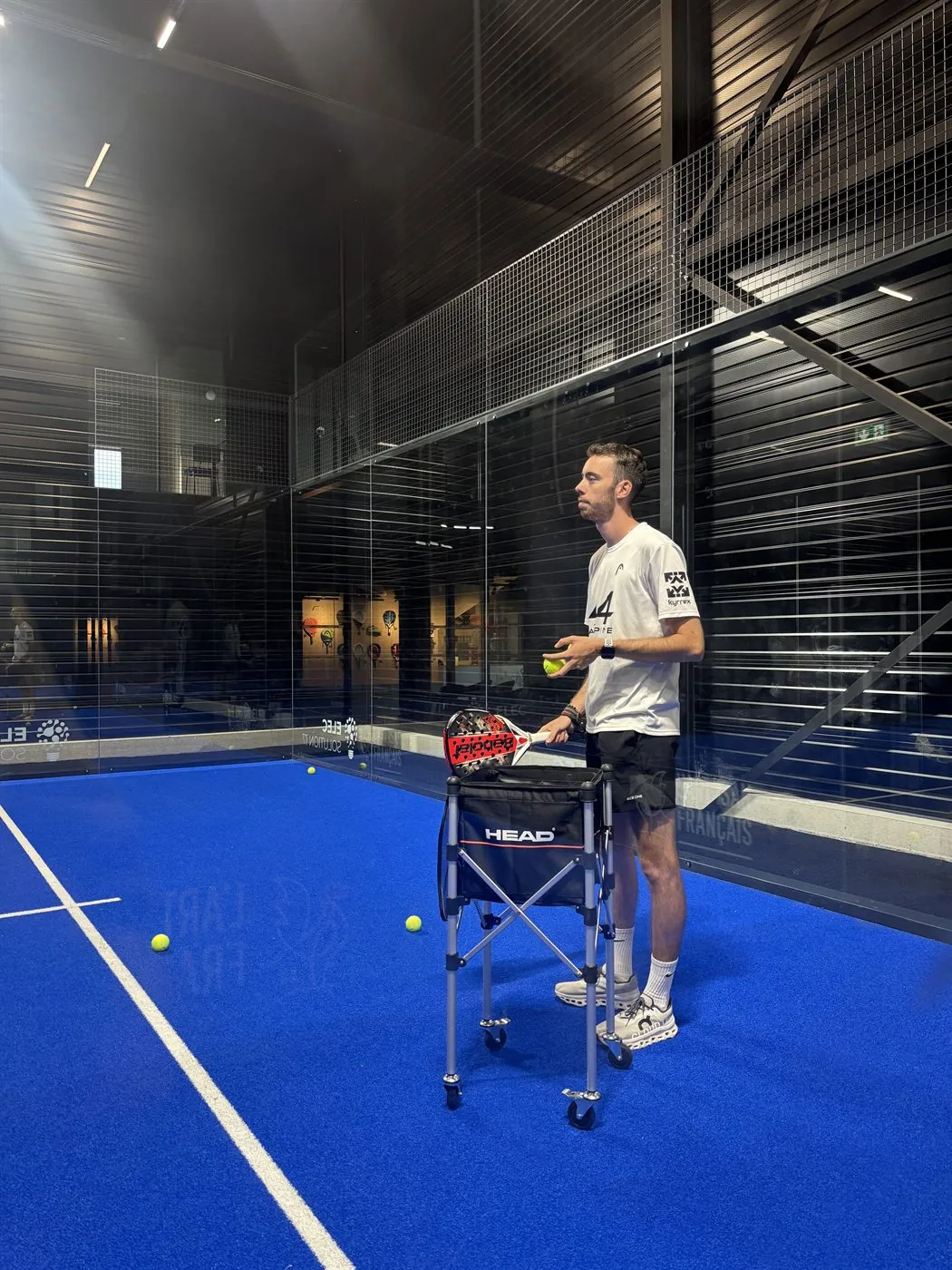 Un coach de Two Padel corrige le geste d'une joueuse sur une piste couverte