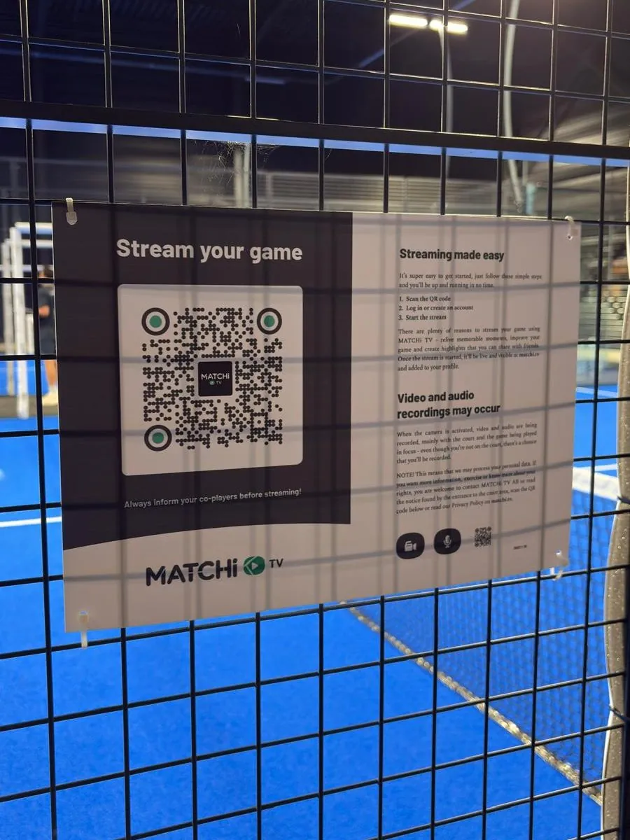 Le panneau MATCHi TV et son QR code, vissé sur le grillage à l'entrée d'une piste de Two Padel